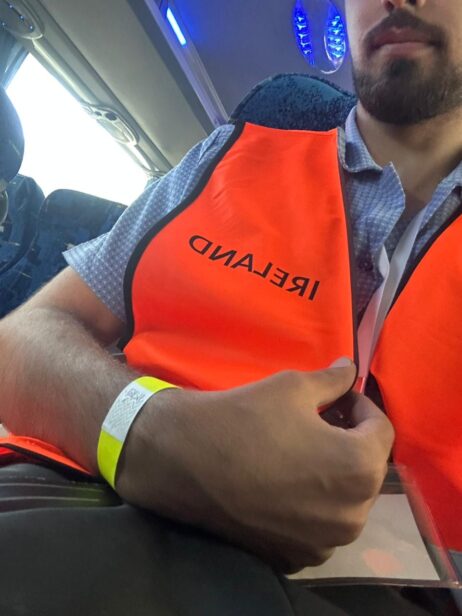 young man wearing an orange vest that says Ireland on it