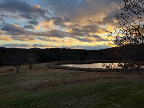 Sunset over a meadow with a pond