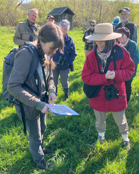 group of bird watchers with an instructor showing a map of bird nest locations